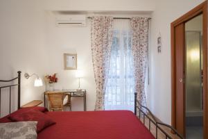 a bedroom with a red bed and a window at Anthea in Naples