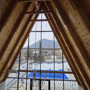 a chandelier in a room with a large window at Luxury A-Frame Forest Chalet in Gabala