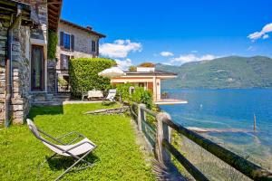 a chair sitting on the grass in front of a house at Casa La Terrazza Uno C in Cannobio
