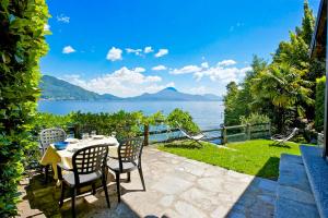 a patio with a table and chairs and a view of the water at Casa La Terrazza Uno C in Cannobio