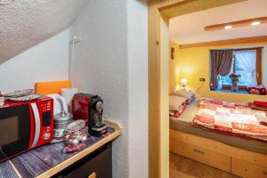 a bedroom with a bed and a microwave on a counter at Ciesa del Selmo Faure in Sottoguda +26 photos