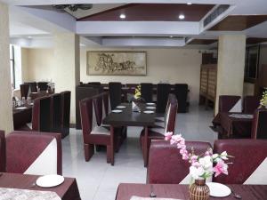 a dining room with a table and chairs in a restaurant at Heritage Tezpur in Tezpur