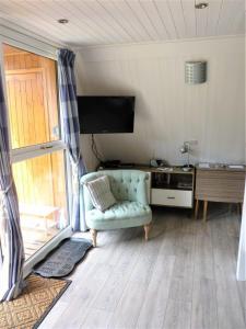 a living room with a blue couch and a television at Chalet 11 in Deal