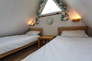 two twin beds in a room with a window at Chalet 11 in Deal