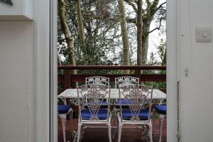 a table and chairs on a porch with trees at Chalet 11 in Deal