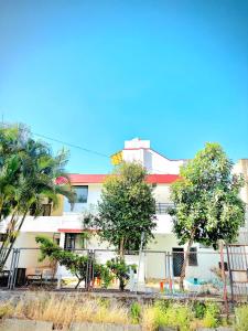 a white building with trees in front of it at ll MOCKTAIL VILLA ll 3BHK ll AC ll PRIVATE POOL ll MALAVALI ll in Lonavala