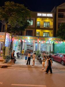 a group of people walking in front of a store at Son Tinh Hotel in Phong Nha +12 photos