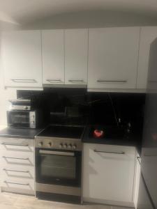 a kitchen with a stove and white cabinets at Zarko Home in Drama