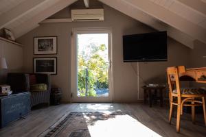 a living room with a large window and a flat screen tv at Kuruma Farm Cottages in Worcester