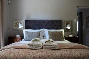 a bedroom with a bed with towels on it at Kuruma Farm Cottages in Worcester