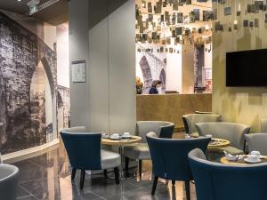 un restaurante con mesas, sillas y TV en Lisbon Sao Bento Hotel, en Lisboa