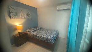 a small bedroom with a bed and a lamp at Casa pequeña in Acapulco