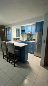 a kitchen with blue cabinets and a table and chairs at Casa pequeña in Acapulco