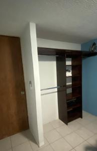 a room with a closet with a refrigerator and a door at Casa pequeña in Acapulco +1 photo