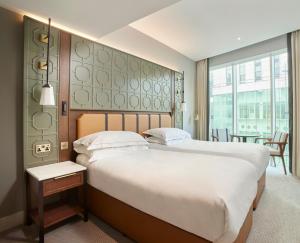 a bedroom with a large bed and a large window at The Parkgate Hotel in Cardiff +65 photos
