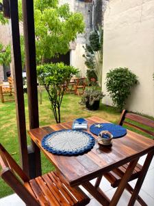 a wooden table with blue plates on top of it at Pousada Casa Marelle in Paracuru +40 photos