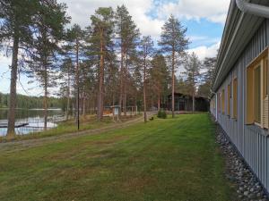 a house with a yard next to a lake at RIEKKO Hostel in Kuusamo +10 photos