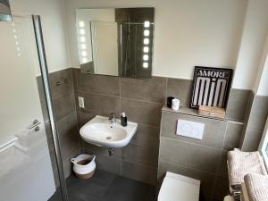 a bathroom with a sink and a toilet and a mirror at Casa Forest Jump in Pirmasens +7 photos