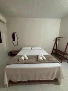a bedroom with a bed with towels on it at Pousada Casa Marelle in Paracuru