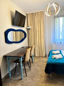 a room with a table and a mirror and a bed at Villa Morska Perła in Rewal