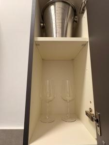 two wine glasses sitting inside of a cabinet at Soul house in Corsico