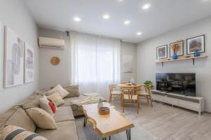 a living room with a couch and a table at NDK - UrbanLux Medius 2BDR FREE Parking in Sofia