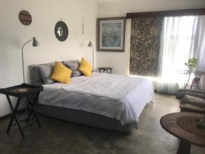 a bedroom with a large bed with yellow pillows at 120 steps to the beach in Pringle Bay