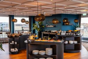 a restaurant with several tables with food on them at Hotel Atlantic in Aarhus