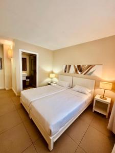 a large white bed in a room with two lamps at Be Cosy Private Villa - Trou aux Biches in Triolet