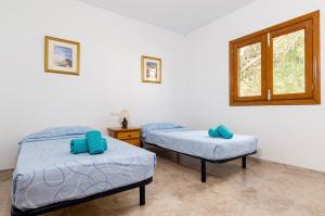 two beds in a room with a window at YourHouse Sol i Mar 1 apartment in Cala Mesquida +39 photos