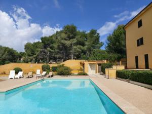 a swimming pool with chairs and a house at YourHouse Sol i Mar 1 apartment in Cala Mesquida