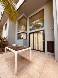 a table in front of a house with windows at Be Cosy Private Villa - Trou aux Biches in Triolet