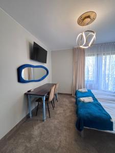 a bedroom with a bed and a desk and a mirror at Villa Morska Perła in Rewal