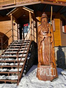 a statue in the snow in front of a building at Penzion Praděd in Malá Morávka
