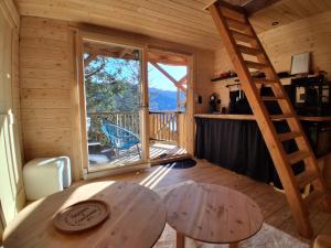 a room with a table and a ladder in a cabin at Hôtel La bonne hôtesse in Chambon-sur-Lac