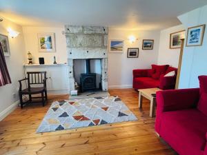 a living room with a red couch and a fireplace at Kivel Cottage in Portland