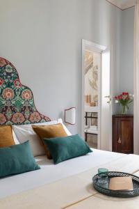 a bedroom with a white bed with green pillows at Hotel Galileo in Florence