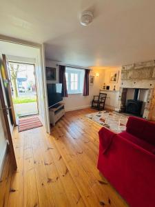 a living room with a red couch and a fireplace at Kivel Cottage in Portland