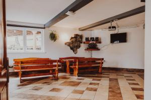 a church with two wooden benches and a window at Dom Wypoczynkowy U STASKA in Ochotnica Dolna