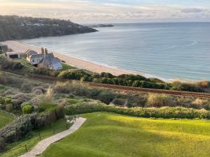 a house on a hill next to the ocean at Aigua Blava in Carbis Bay