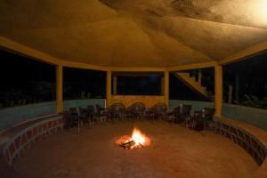 a fire pit in a tent with chairs around it at Treebo Premium Mowgli's Den, Pench Tiger Reserve, Turia in Khawāsa