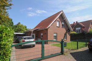 a green fence in front of a house at Ferienhaus Carpe Diem in Greetsiel