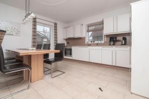 a kitchen with white cabinets and a wooden table at Ferienhaus Carpe Diem in Greetsiel