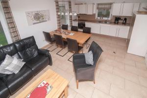 a living room with a couch and a table and chairs at Ferienhaus Carpe Diem in Greetsiel