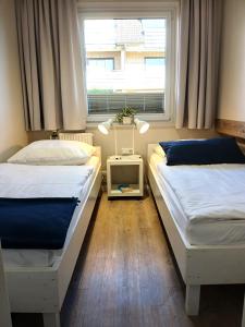two beds in a room with a window at Haus Triton in Büsum