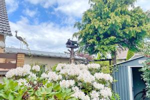 a bird house on the roof of a house with flowers at Gartenblick in Lübbenau