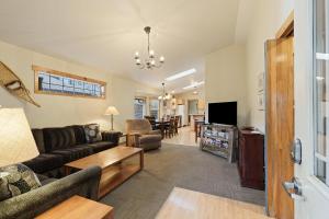 a living room with a couch and a tv at Huckleberry Cottage in Bend