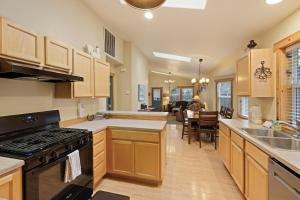 a kitchen with wooden cabinets and a stove top oven at Huckleberry Cottage in Bend