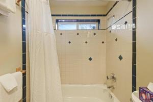 a bathroom with a tub and a shower curtain at Huckleberry Cottage in Bend +23 photos