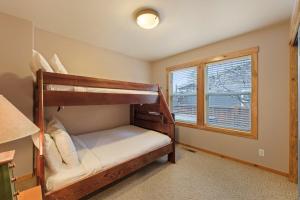 two bunk beds in a room with a window at Huckleberry Cottage in Bend